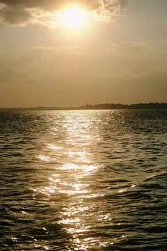 Sunset sunlight water reflection horizon sky create golden ripples across c.. Stock Photos