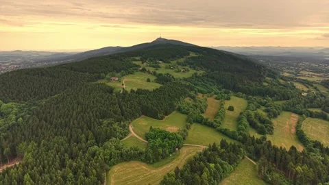 Sunset sunlit aerial panorama over forested hilltop, verdant valley village, Stock Footage 345286706