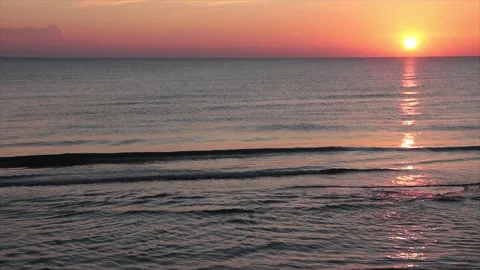 Sunset sunrise above water ocean lake with orange sky medium wide shot with sun Stock Footage 252153913