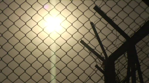 Sunset through barbed wire fence Stock Footage 134743