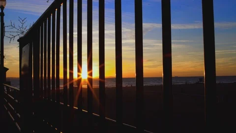 Sunset through bars by beach, 4K Stock Footage 101002352