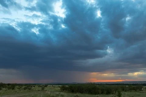 Sunset through the clouds in the Masai Mara. Great herds during migration Stock Photos