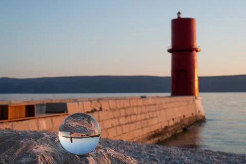 Sunset through glass sphere at the lighthouse of Cres Stock Photos
