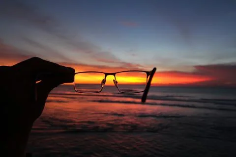 Sunset through glasses in a hand Foto stock