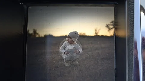 Sunset through a viewfinder: a smiling child playfully sticks out tongue. Stock Footage 317773401