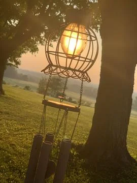 Sunset through wind chime on trees Stock Photos