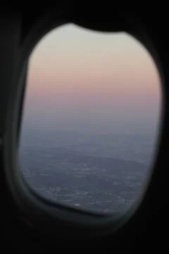 Sunset through the window of an airplane taking off Stock Photos