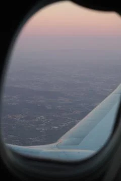 Sunset through the window of an airplane taking off from Porto, Portugal Stock Photos
