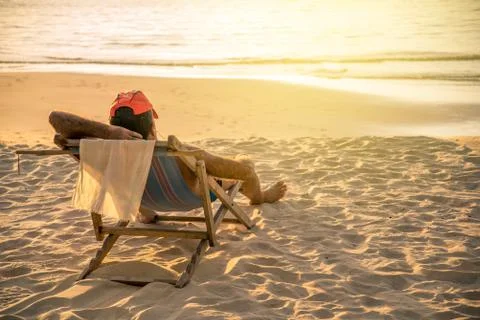 Sunset time and man in hat on vacation. Stock Photos
