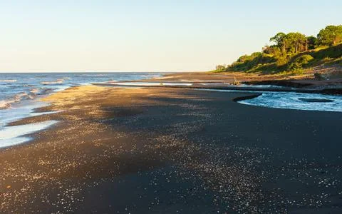 Sunset time on an empty sea beach Stock Photos
