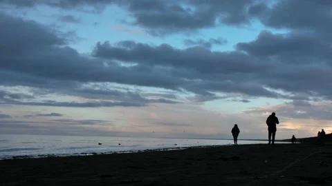 Sunset time in Jurmala beach, people walk on the shore silhouette time Stock Footage 237025549