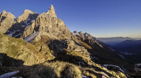 Sunset time-lapse across snowy mountains and valley forest. Video stock 68315443