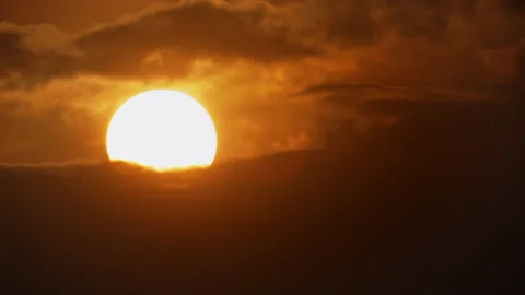 Sunset time lapse. The bright, round, yellow disk of the setting sun, against Stock Footage 225640913