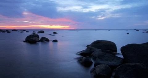 Sunset time lapse of clouds on a rocky shore Stock Footage 101740530