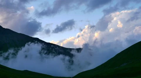 Sunset Time lapse of fog and clouds rolling over the mountain green hills Vídeos de archivo 65764033