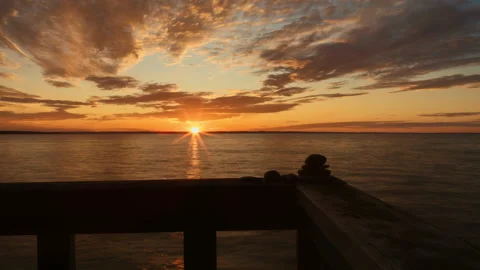 Sunset time-lapse as golden clouds fly over water Stock Footage 158896815