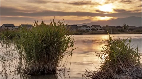Sunset time lapse of a lake in a suburban neighborhood with a brilliantly Vidéo 140478990