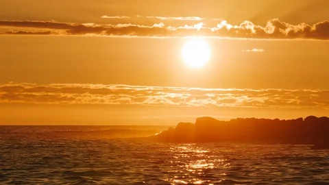 Sunset time lapse on ocean behind rocky island in silhouette. Stock Footage 111400121