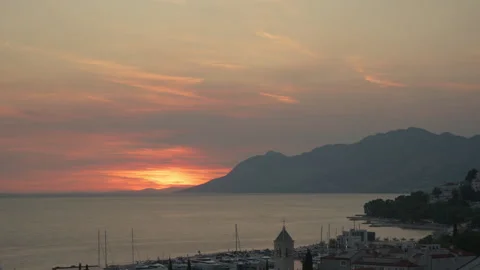 Sunset time lapse over Baska Voda resort and harbor on Adriatic coast in Croatia Video stock 345972937