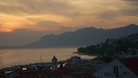 Sunset time lapse over coastal resort town of Baska Voda in Croatia by the sea Video stock 345972871