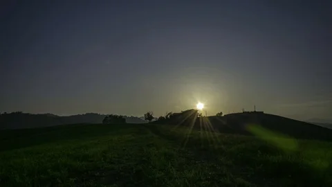 Sunset time lapse over a grassy hill with a house Stock Footage 118906752