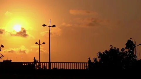 Sunset Time lapse skyline city silhouette on a bridge, people walking Stock Footage