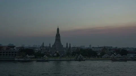 Sunset time lapse of Wat Arun temple and boat traffic at Chao Phraya river at Ba Stock Footage 155449861