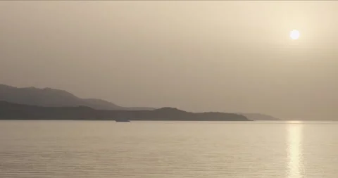 Sunset time at sea, orange sun high above the sea, mountains and sea surface Vídeos de archivo 178355669