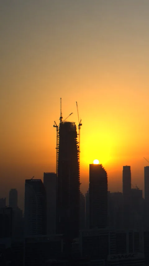 Sunset timelapse of Dubai skyline with construction crane silhouettes Stock Footage 341775368