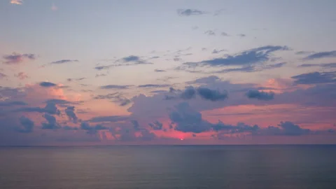 Sunset timelapse over calm sea with colorful purple and pink clouds Stock Footage 341756590