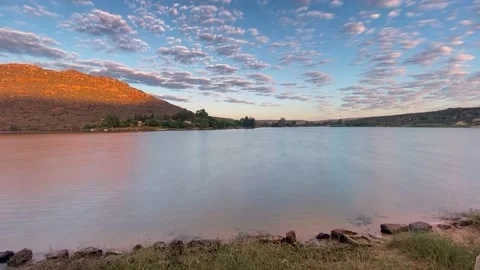 Sunset timelapse over dam as puffy clouds roll over Stock Footage 189970545