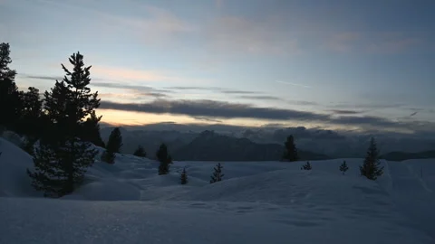 Sunset timelapse over snowy alpine plateau with clouds, mountains, airplane, 4K Stock Footage 330737005