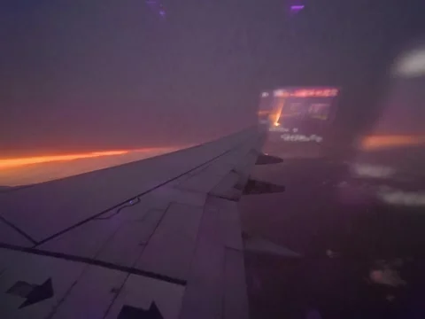 Sunset timelapse video of airplane wing flying in sky, city lights colourful clo Stock-Footage 318948930