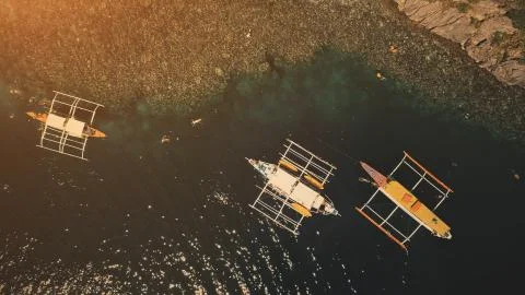 Sunset top down at ocean bay: passengers swim, dive at boats aerial shot Stock Photos