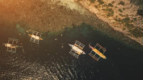 Sunset top down at ocean bay: passengers swim, dive at boats aerial shot Stock Photos