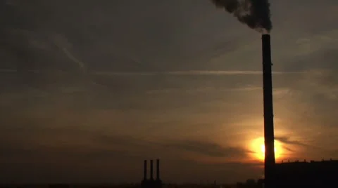 A sunset with the tower and steam in an industrial landscape Stock Footage