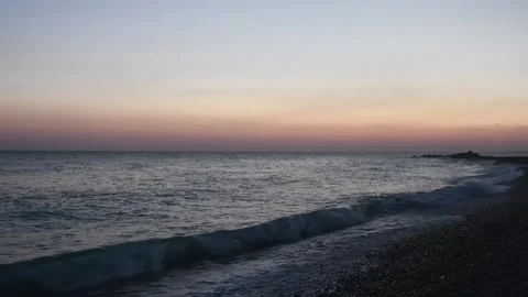 Sunset on a tranquil beach in Oman with gentle waves and a serene sky Stock Footage 318824390