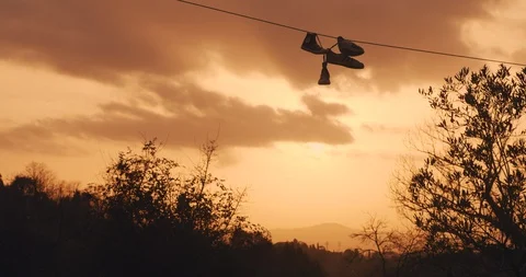 Sunset in Tuscany with Sneakers hanging on power lines Stock Footage 129351353