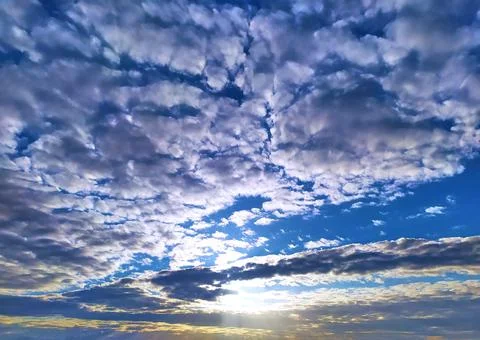 Sunset under wadded clouds on a BLUE SKY BACKGROUND Stock Photos
