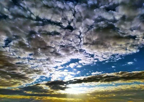Sunset under wadded clouds on a dark sky background Stock Photos