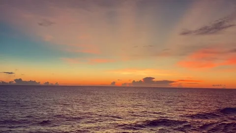 Sunset with vibrant colors over calm ocean waves under a clear sky capturin.. Stock Footage 338280446