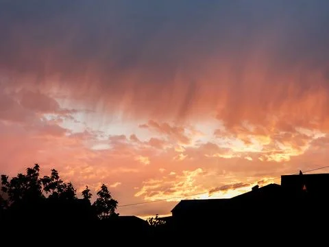 Sunset with vibrant colors over rooftops and trees Foto stock