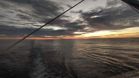 The sunset view from aboard the ship, with the ship’s ropes visible. Stock Footage 311489845
