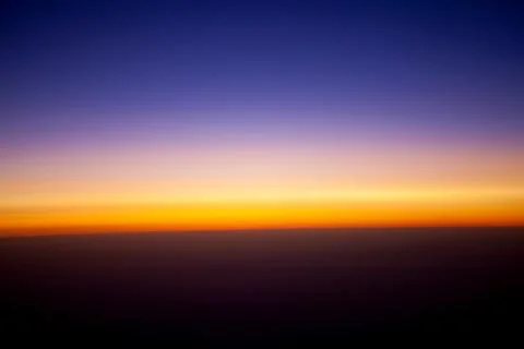 Sunset view above the clouds seen from airplane window Stock Photos