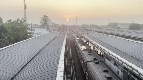 Sunset View Above Commuter Railway Station and Train Tracks Stock Footage 337522127