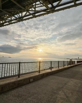 Sunset View Along a Waterfront Path Under a Bridge in Kobe Stock Photos