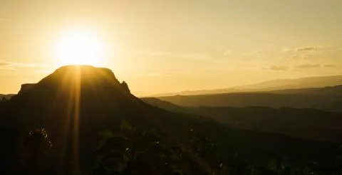 Sunset view behind the silhouettes of some low mountains. Stock Photos