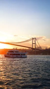 Sunset view of Bosphorus Bridge and ferry in Istanbul, for vertical wallpaper Foto stock