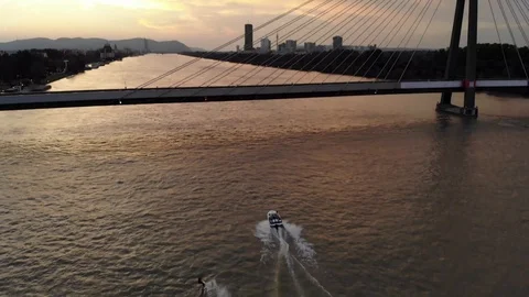 Sunset view of bridge with river and waterski driver Stock Footage 116713552