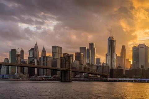 Sunset view of Brooklyn Bridge with lower Manhattan skyline in background on Stock Photos